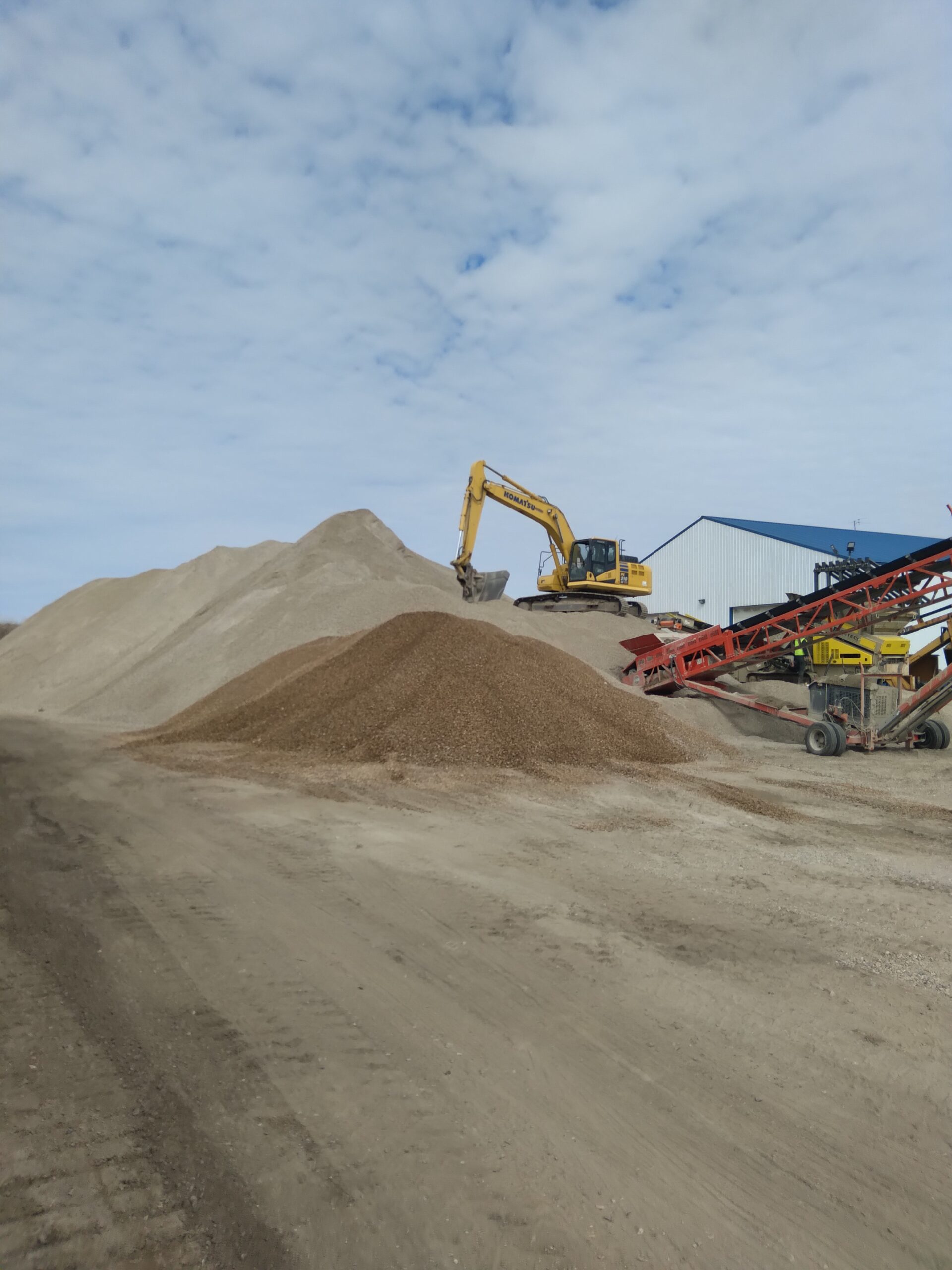 sand pile jobsite with an excavator.