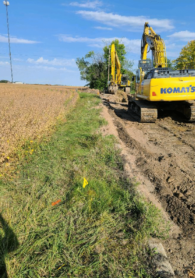Road excavation by Crow River Construction for sewer water line installation.