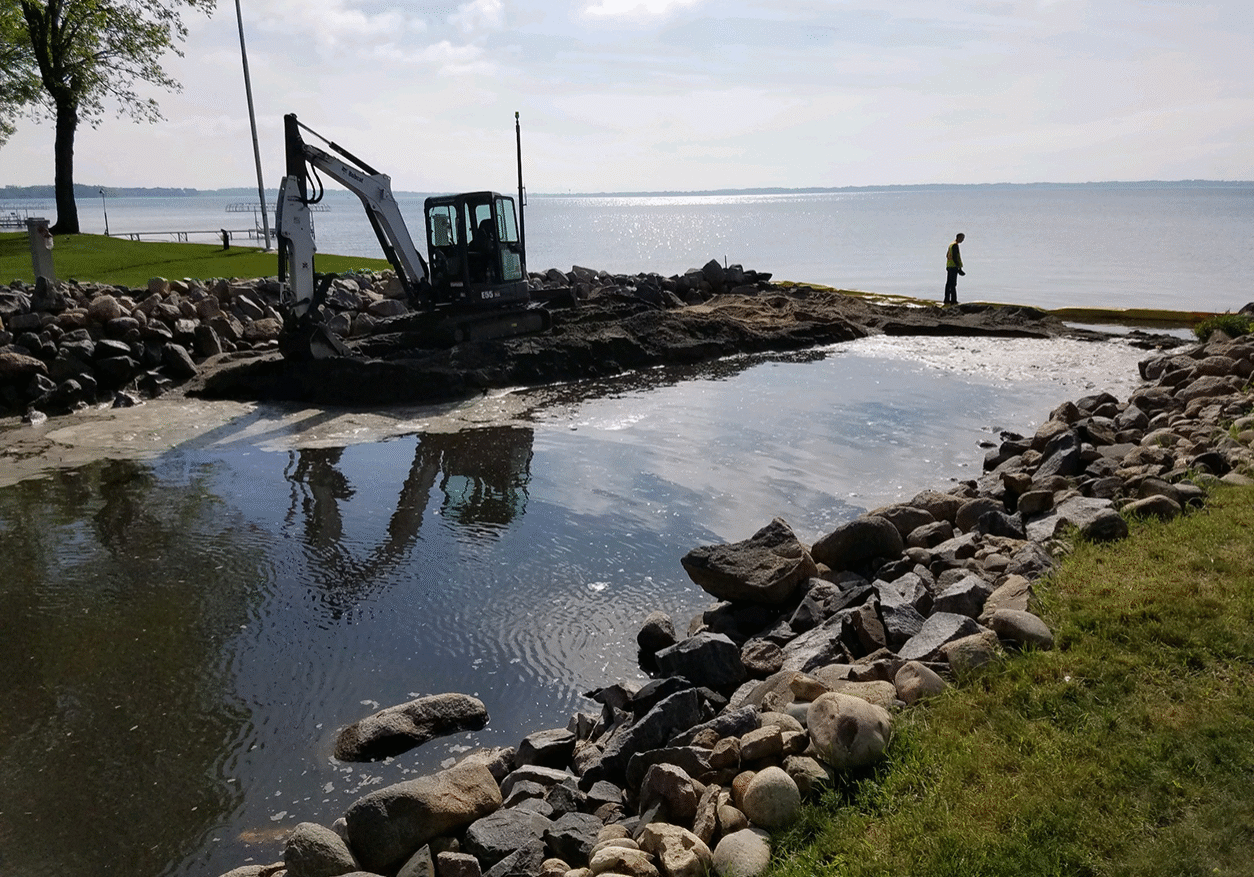 Crow River Construction workers installing erosion control measures to protect the shore line.
